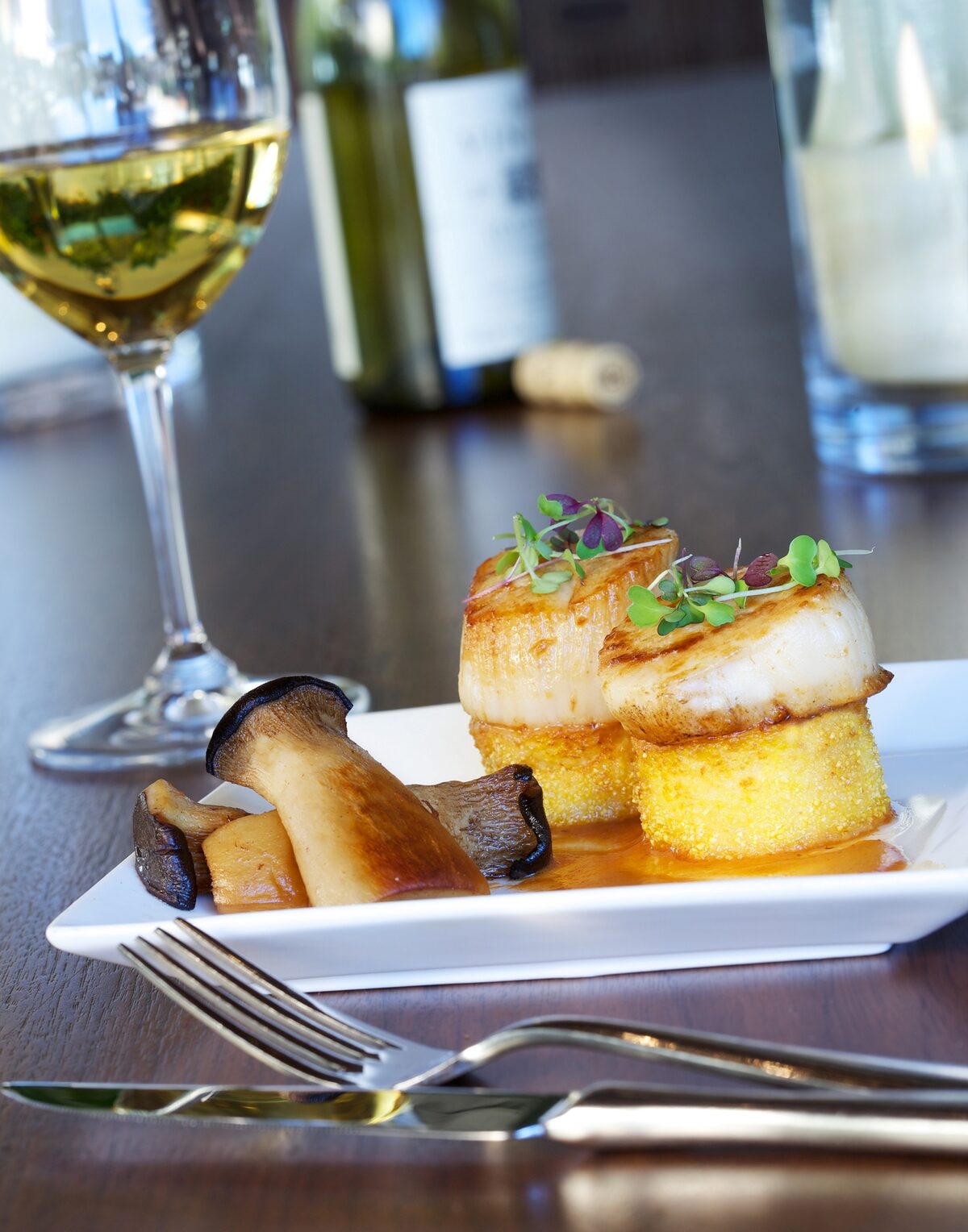 Two seared diver scallops on rounds of crisp polenta with king trumpet mushrooms